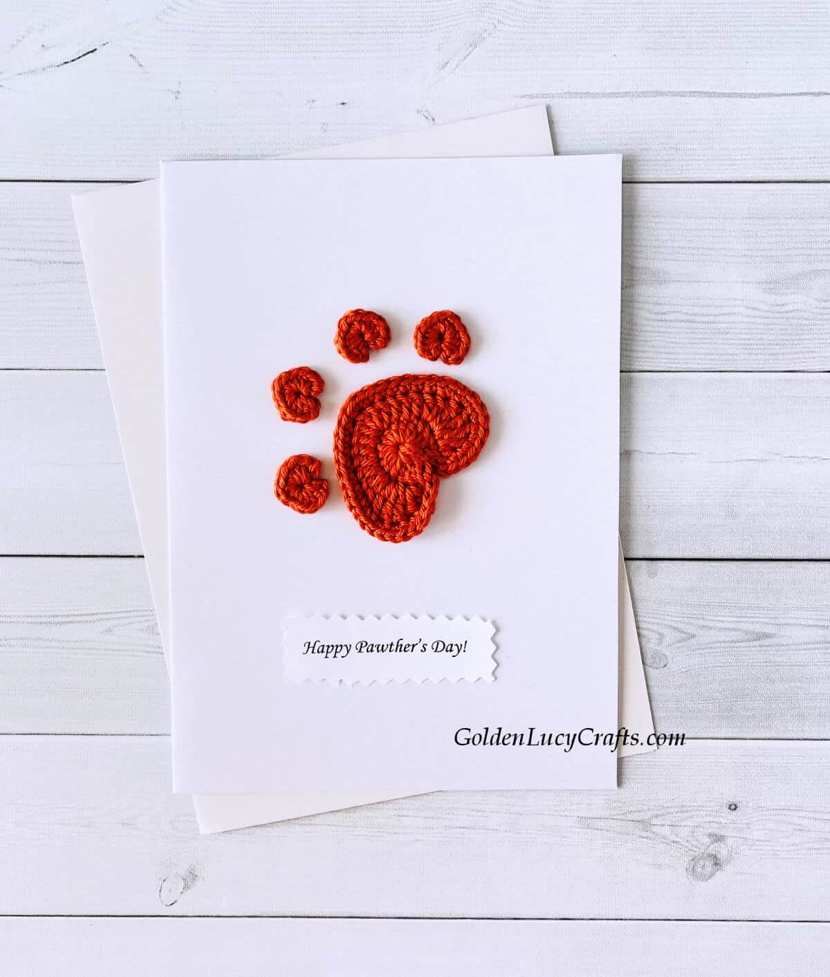 Crochet paw print applique on a white card with the text "Happy pawther's day!"
