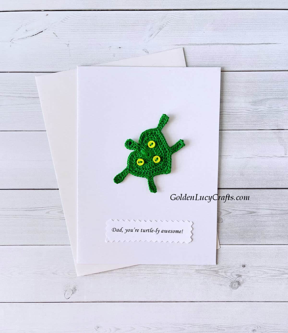 Crochet green turtle applique on a white card with the text "Dad, you are turtlely awesome!"