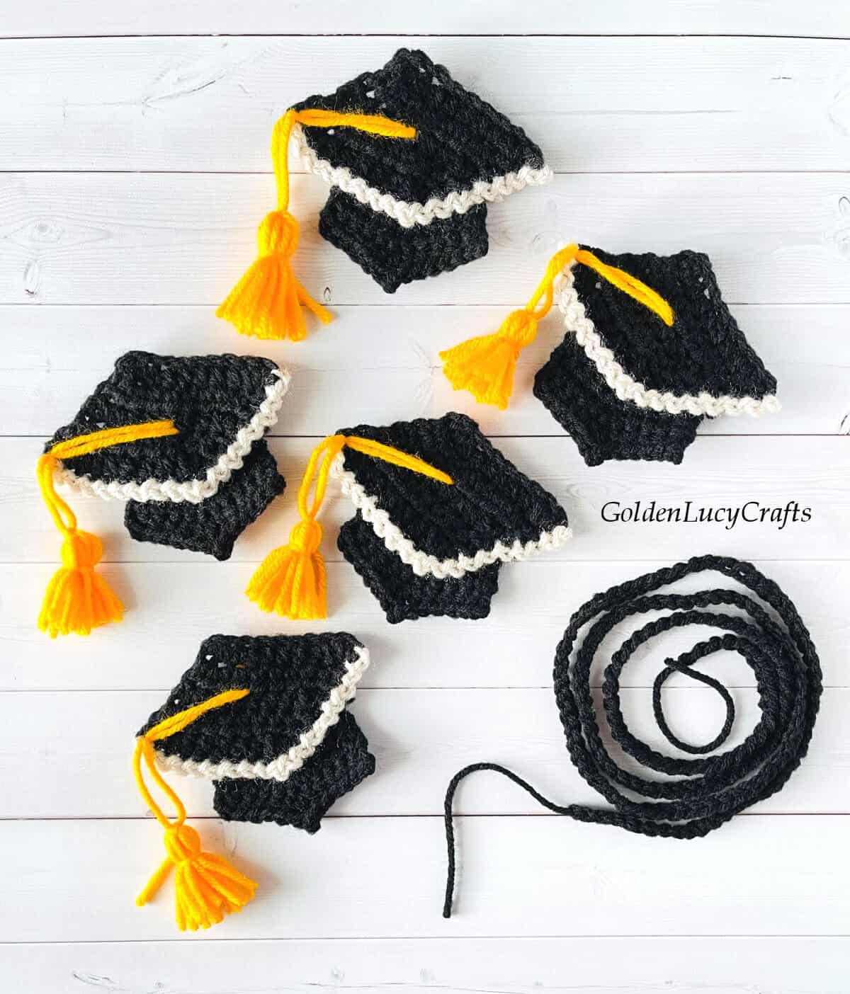 Five crocheted graduation caps and crocheted string.