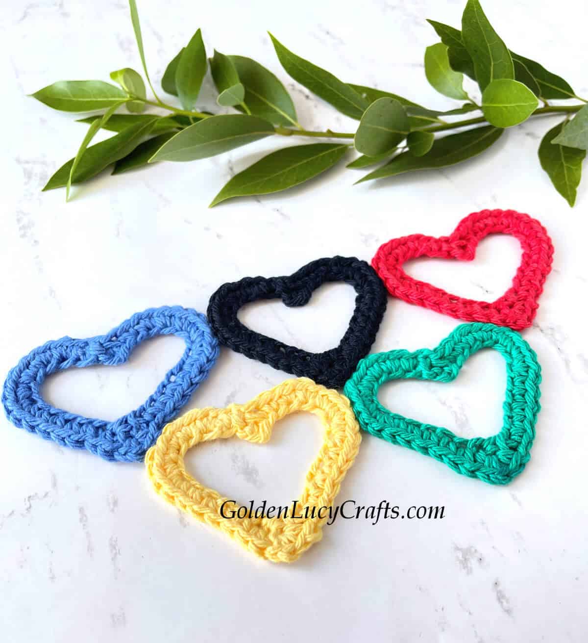 Crocheted heart-shaped Olympic rings close up picture.