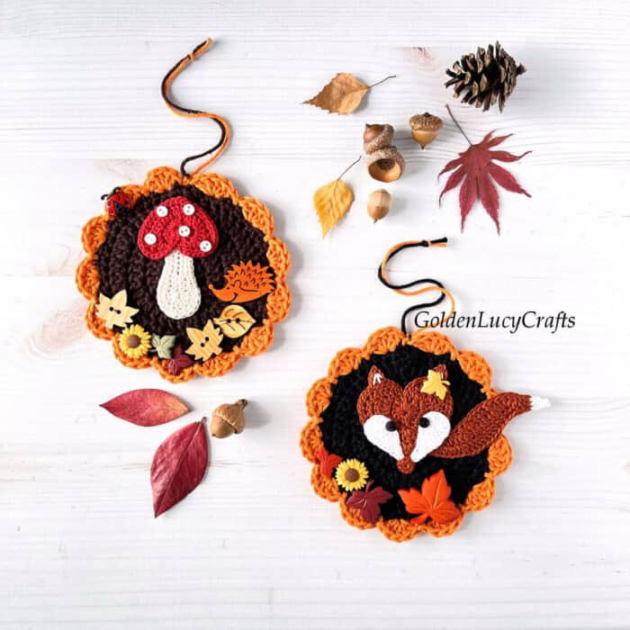 Two crochet Fall-themed round ornaments, leaves, acorn, and pine cone.