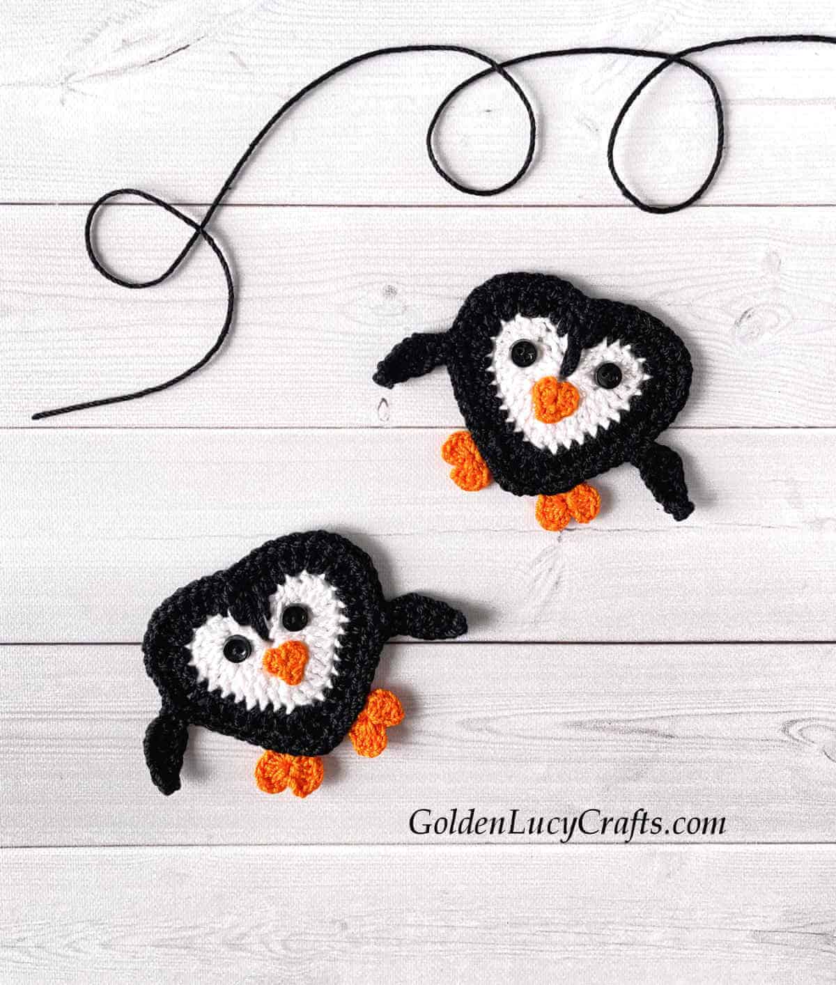 Two heart-shaped penguins crochet applique.