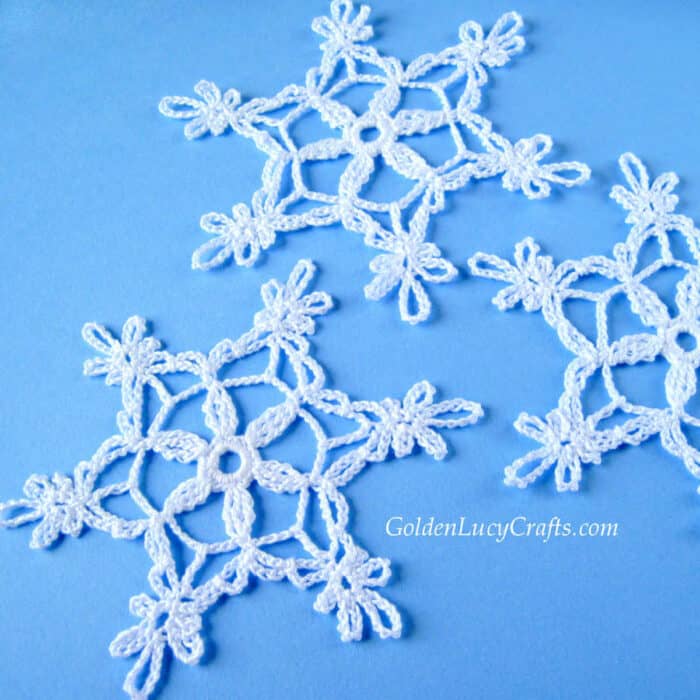 Crocheted snowflakes on blue background.