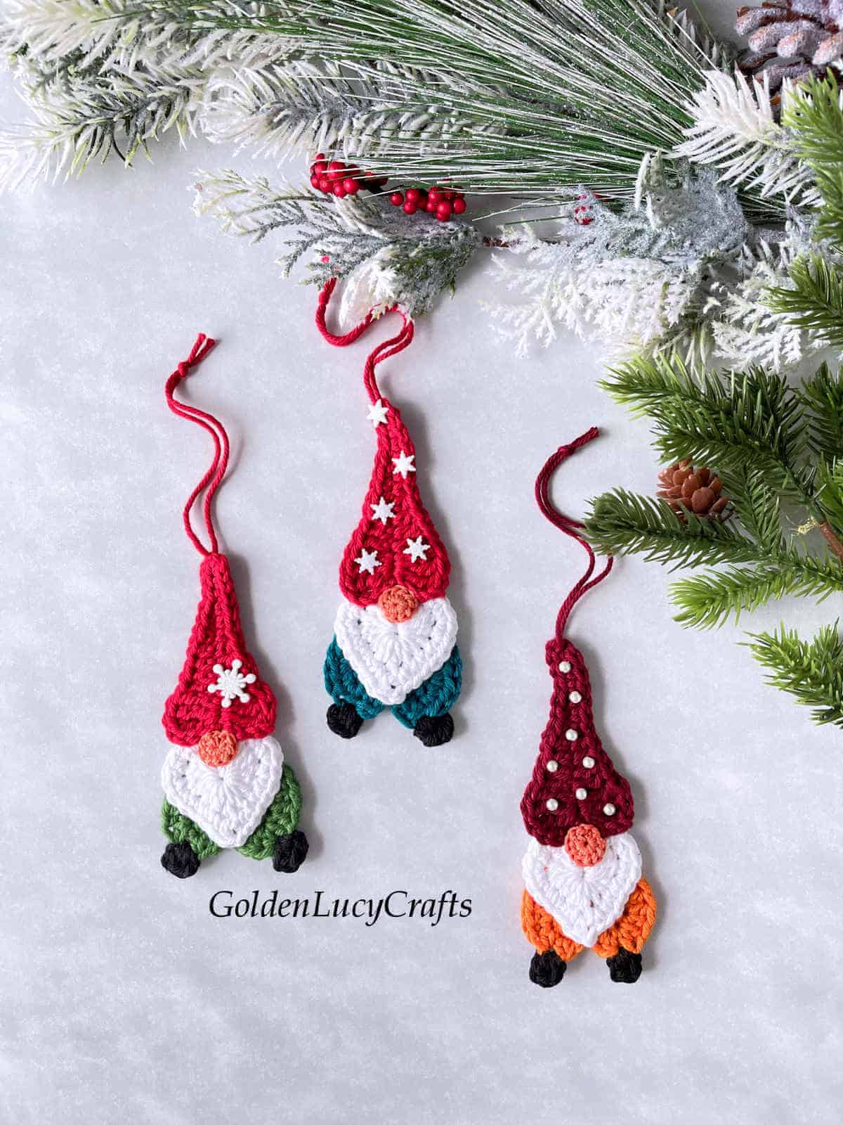 Three crocheted Christmas gnome ornaments.