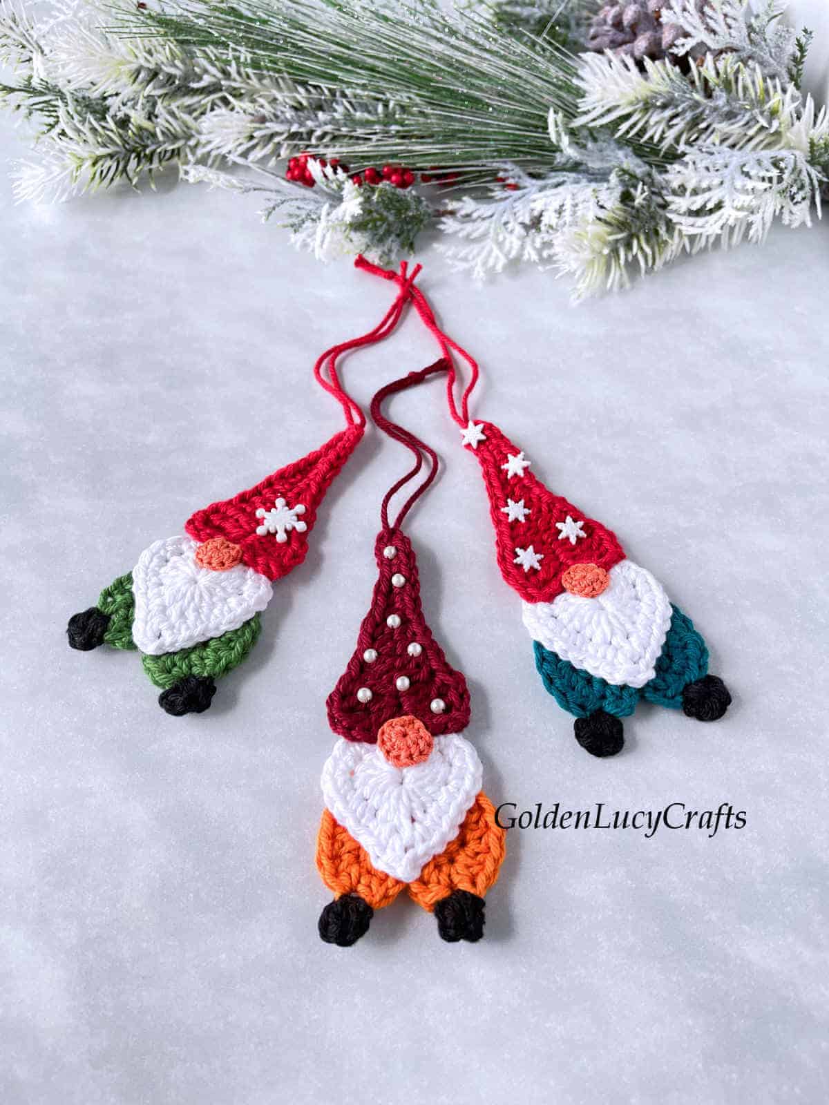 Three crocheted Christmas gnomes.