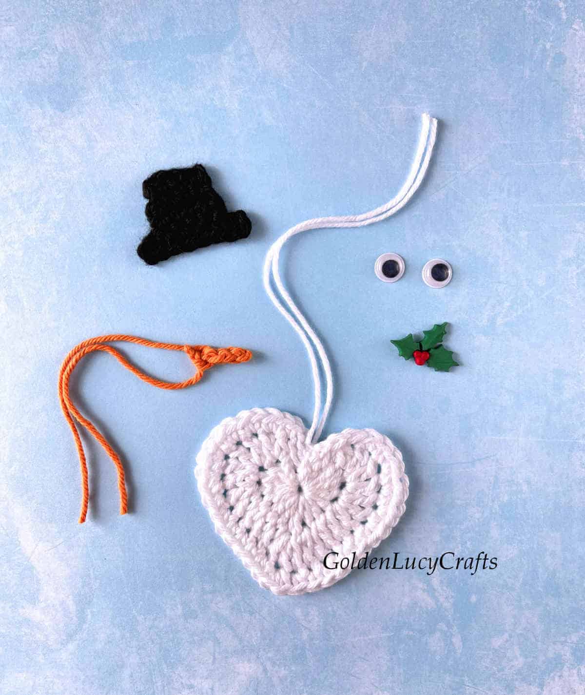 Parts of crochet heart snowman ornament.