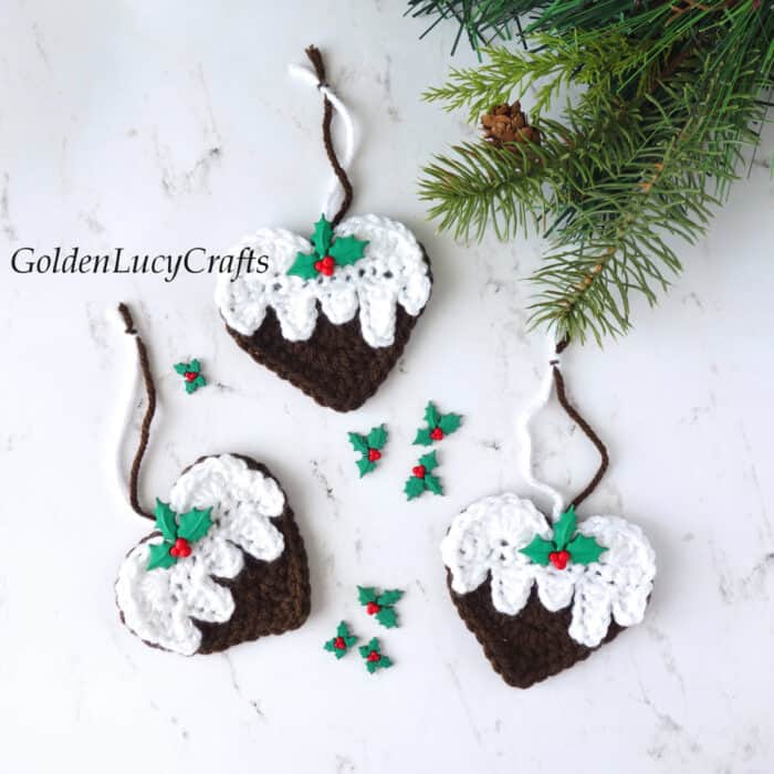 Three crochet Christmas pudding ornaments embellished with holly berry buttons.