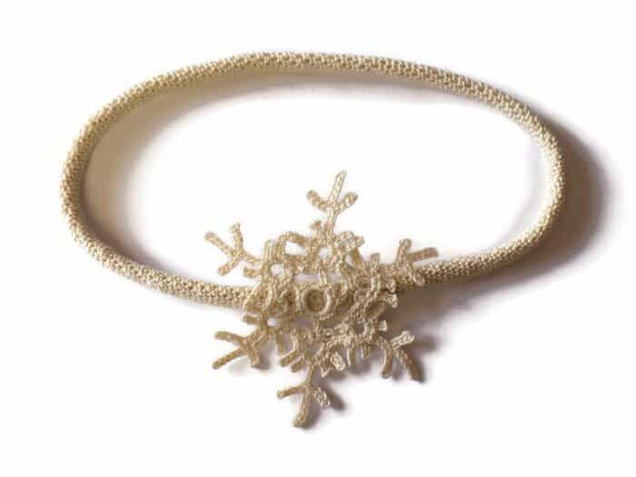 Crochet headband embellished with snowflake.