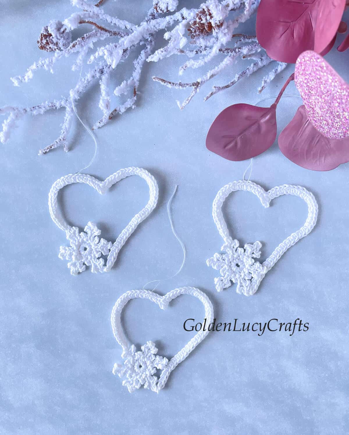Three crocheted white hearts with small snowflakes.