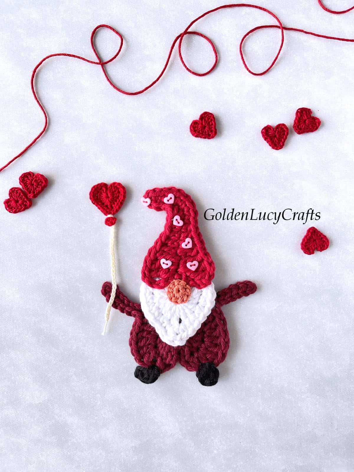 Crochet Valentine's Day gnome with heart balloon in his hand.