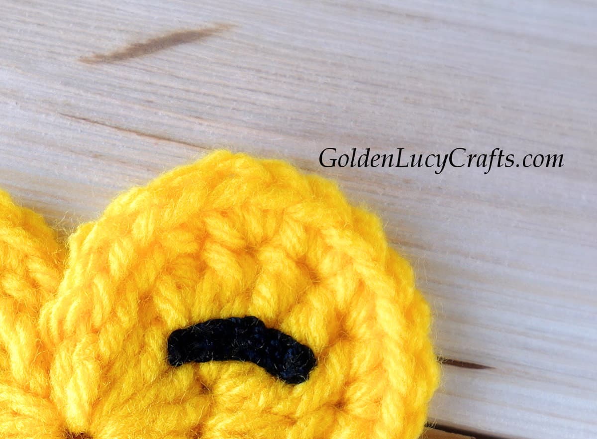 Crochet emoji, closed eye, close up picture.