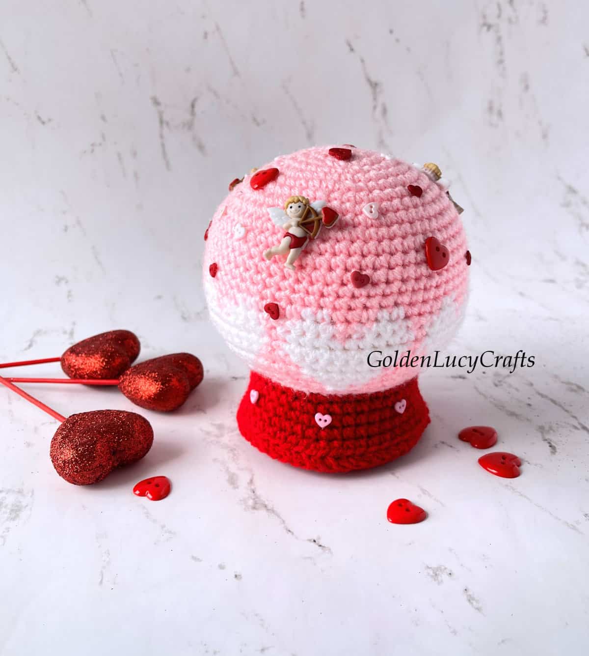 Crocheted snow globe Valentine's Day snow globe embellished with decorative buttons.