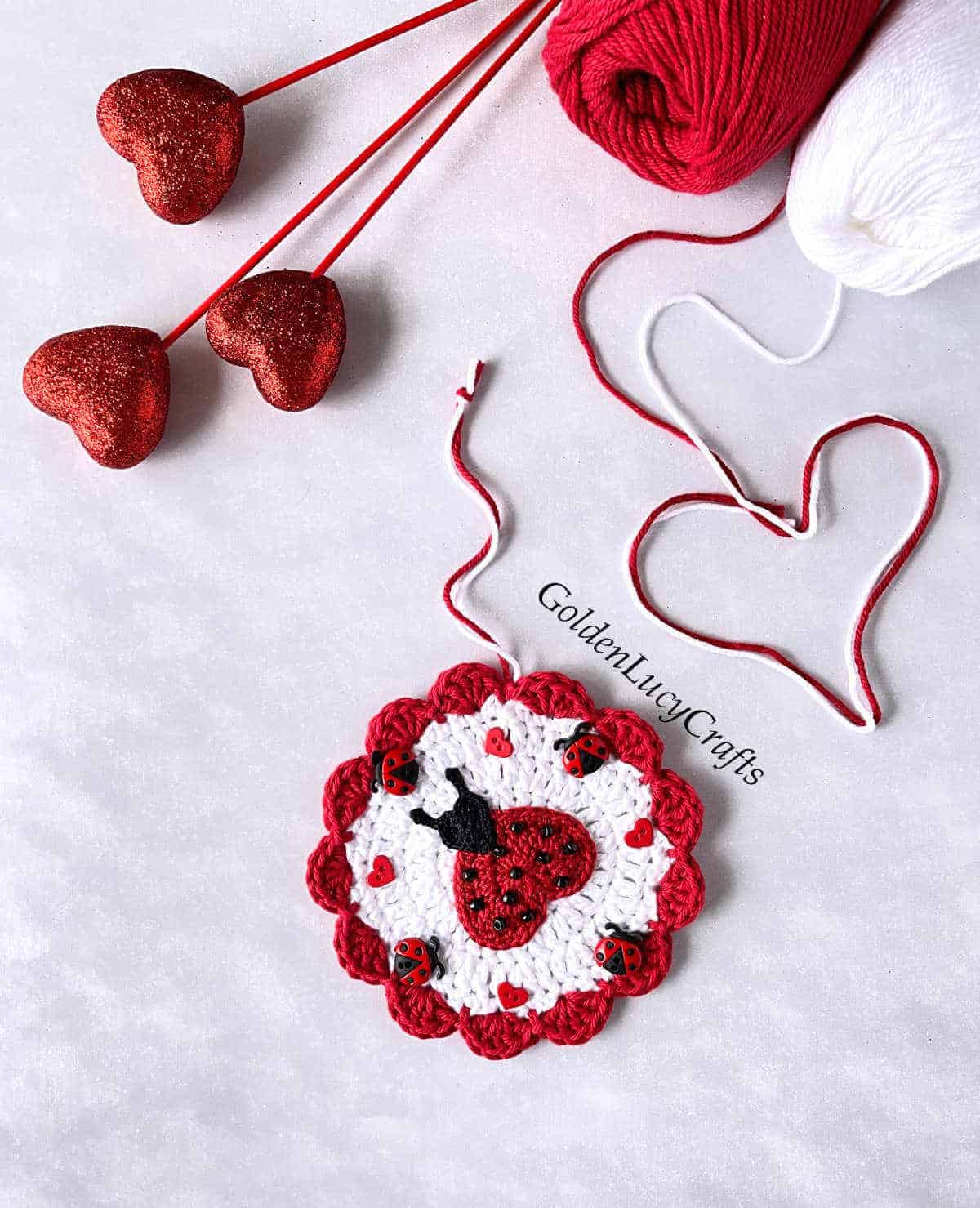 Crochet round ornament embellished with heart ladybug applique.
