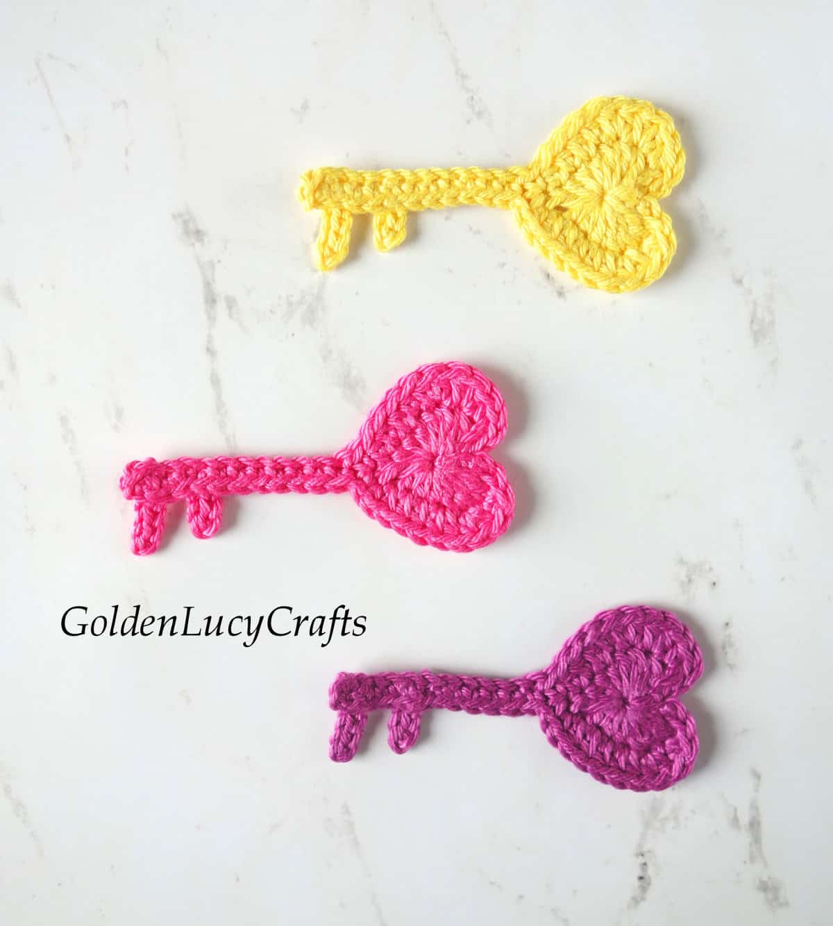 Three crochet heart-shaped key appliques.