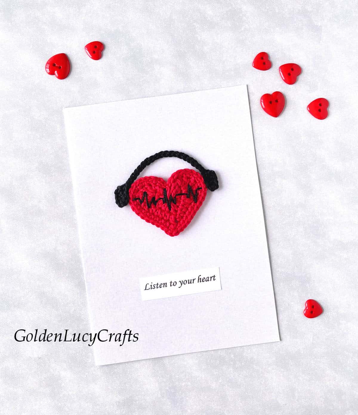 White card with crocheted applique red heart with headphones, text saying listen to your heart.