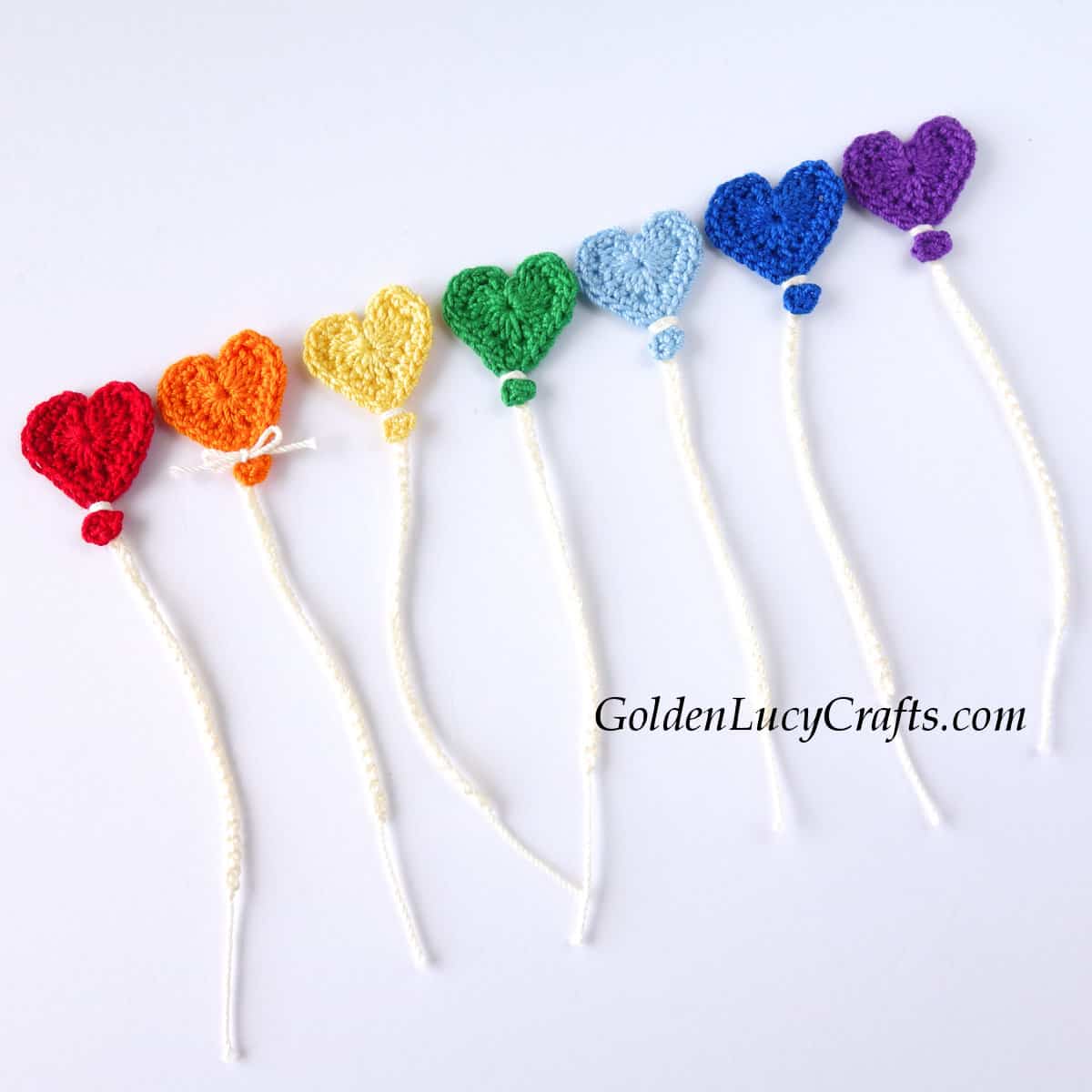 Crocheted heart balloons in rainbow colors.
