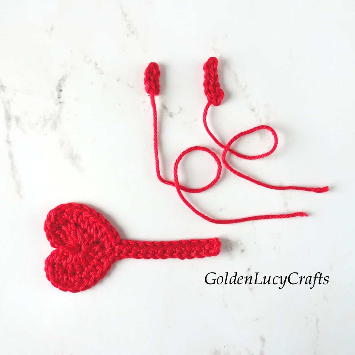 Parts of crocheted heart-shaped key.