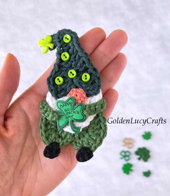 Crochet St Patrck's Day gnome applique in the palm of a hand.