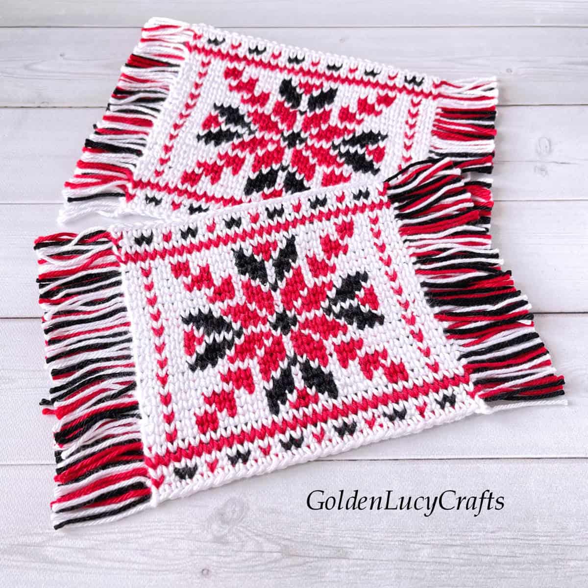 Two crocheted coasters in red, black and white colors.