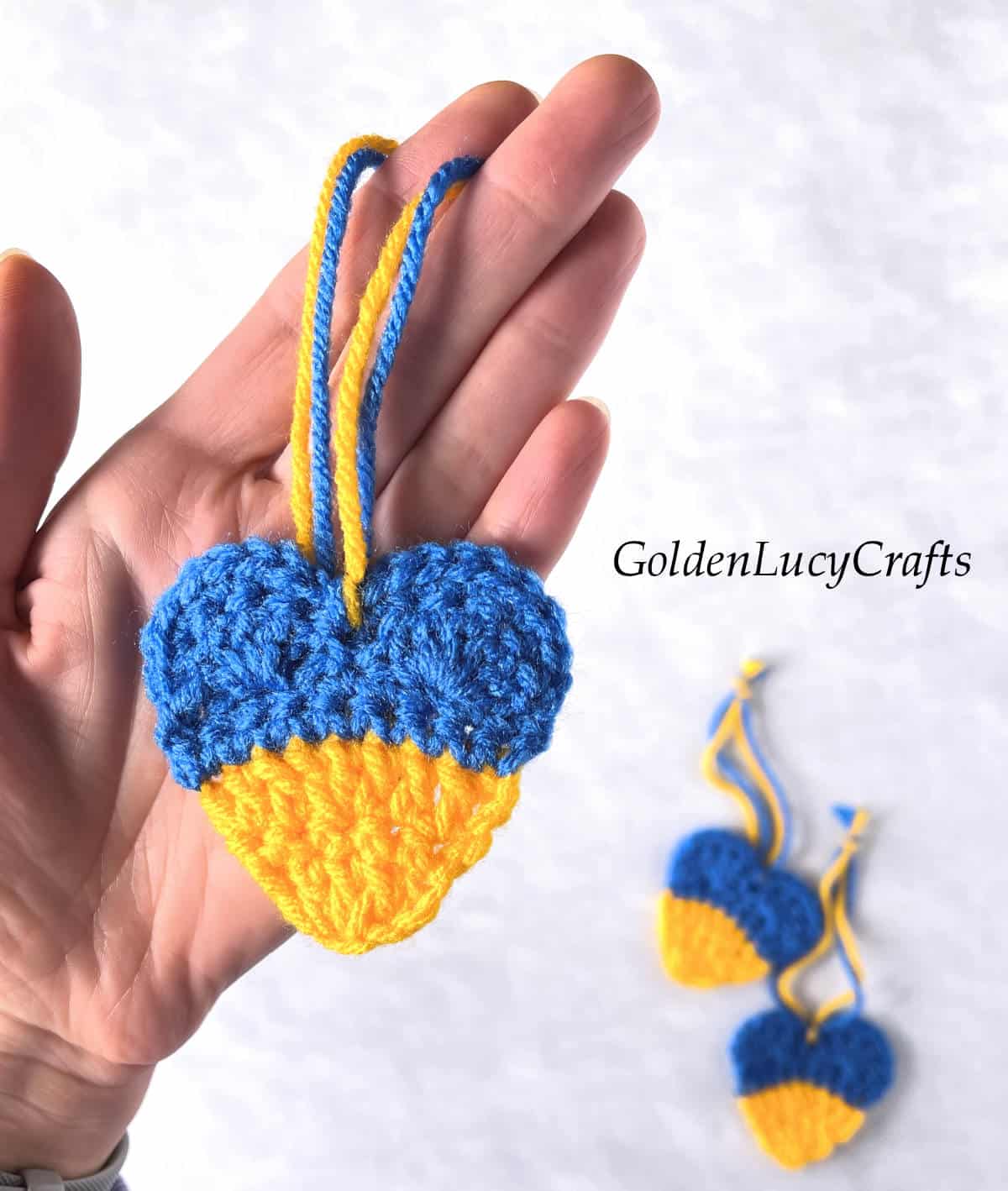 Crochet Ukrainian heart in the palm of a hand.