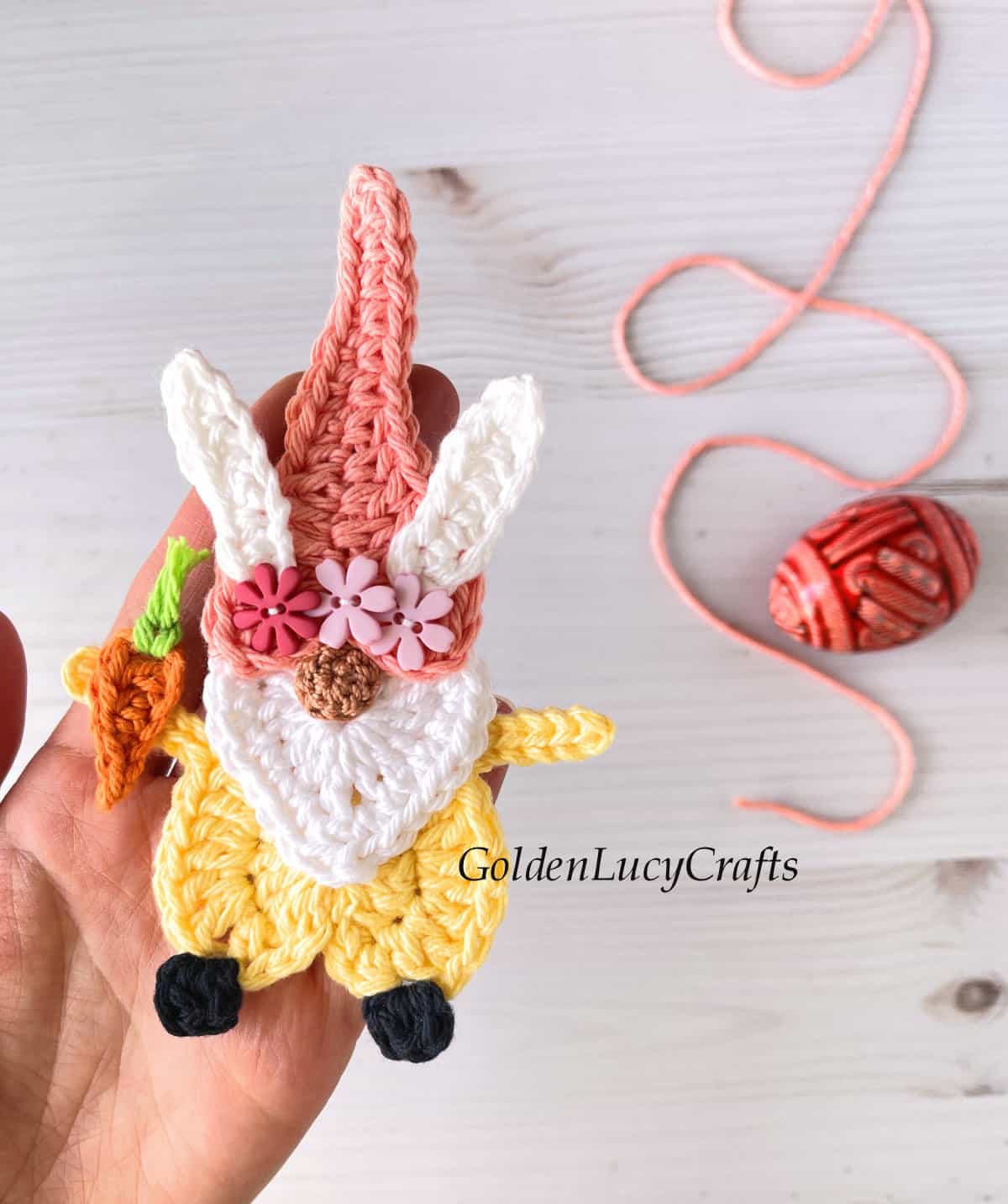 Crocheted Easter gnome applique in the palm of a hand.
