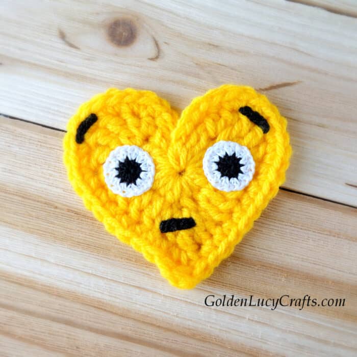 Crochet heart emoji applique surprised face.