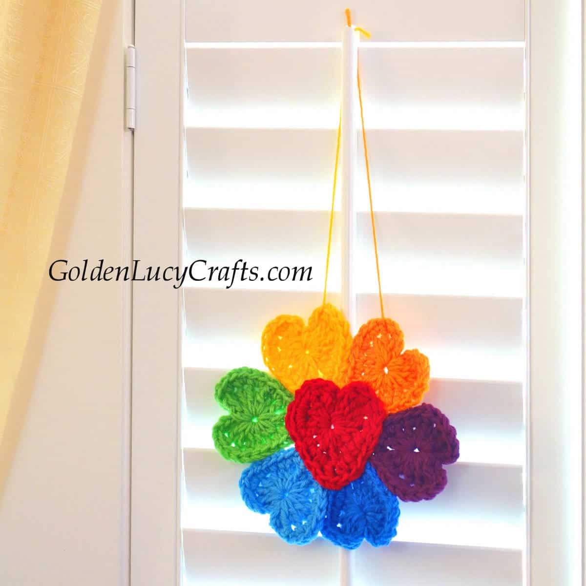Crochet rainbow flower hanging on the window.