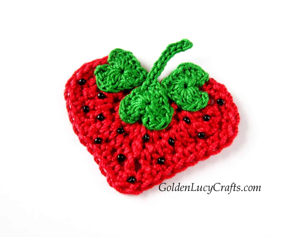Crochet heart-shaped strawberry applique embellished with tiny beads.