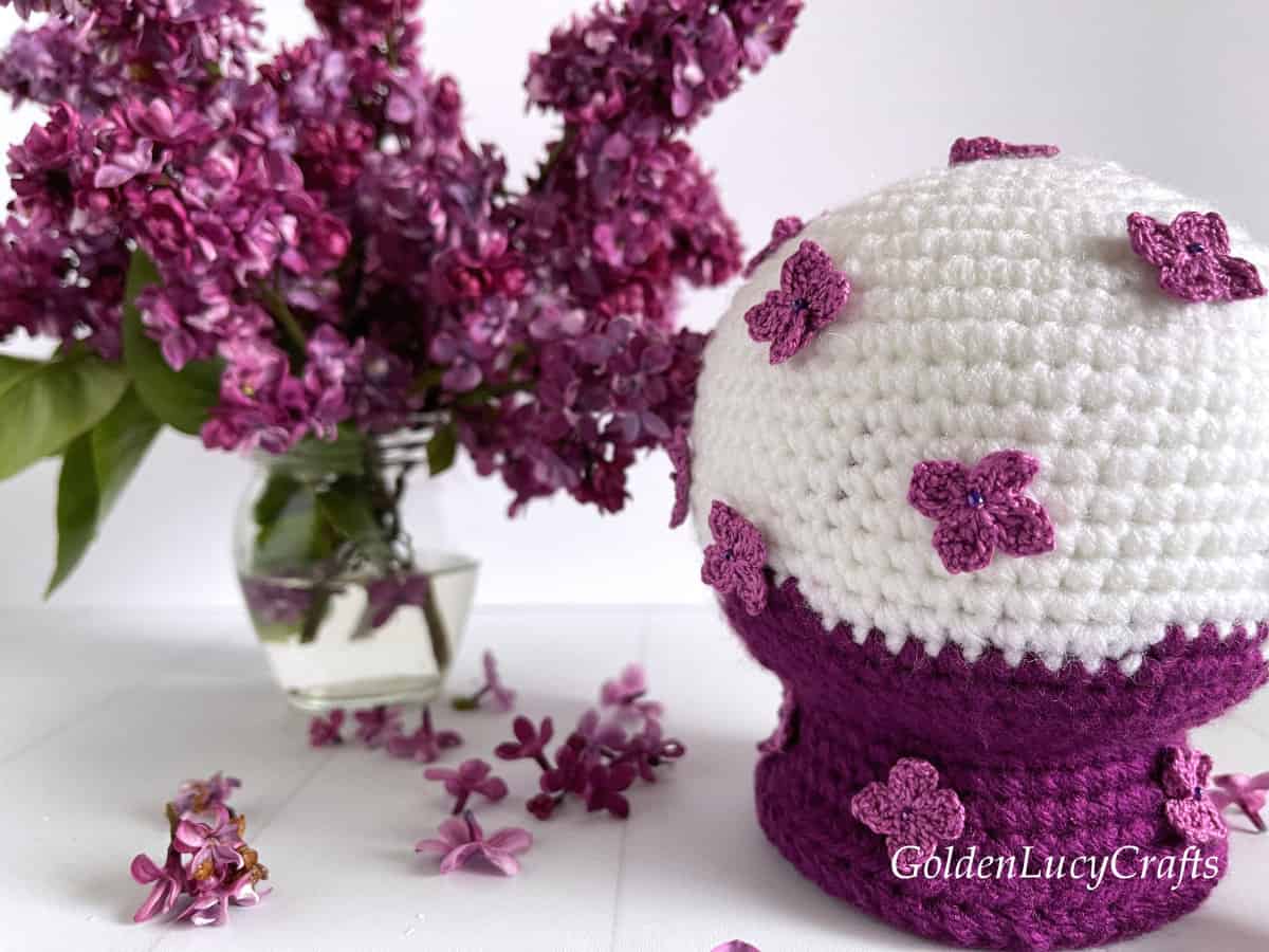 Crochet lilac snow globe, lilac flowers in vase close up picture.