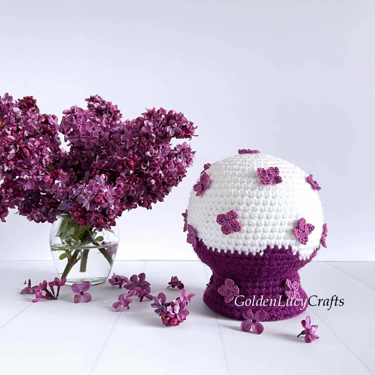 Crochet lilac snow globe, lilac flowers in vase.