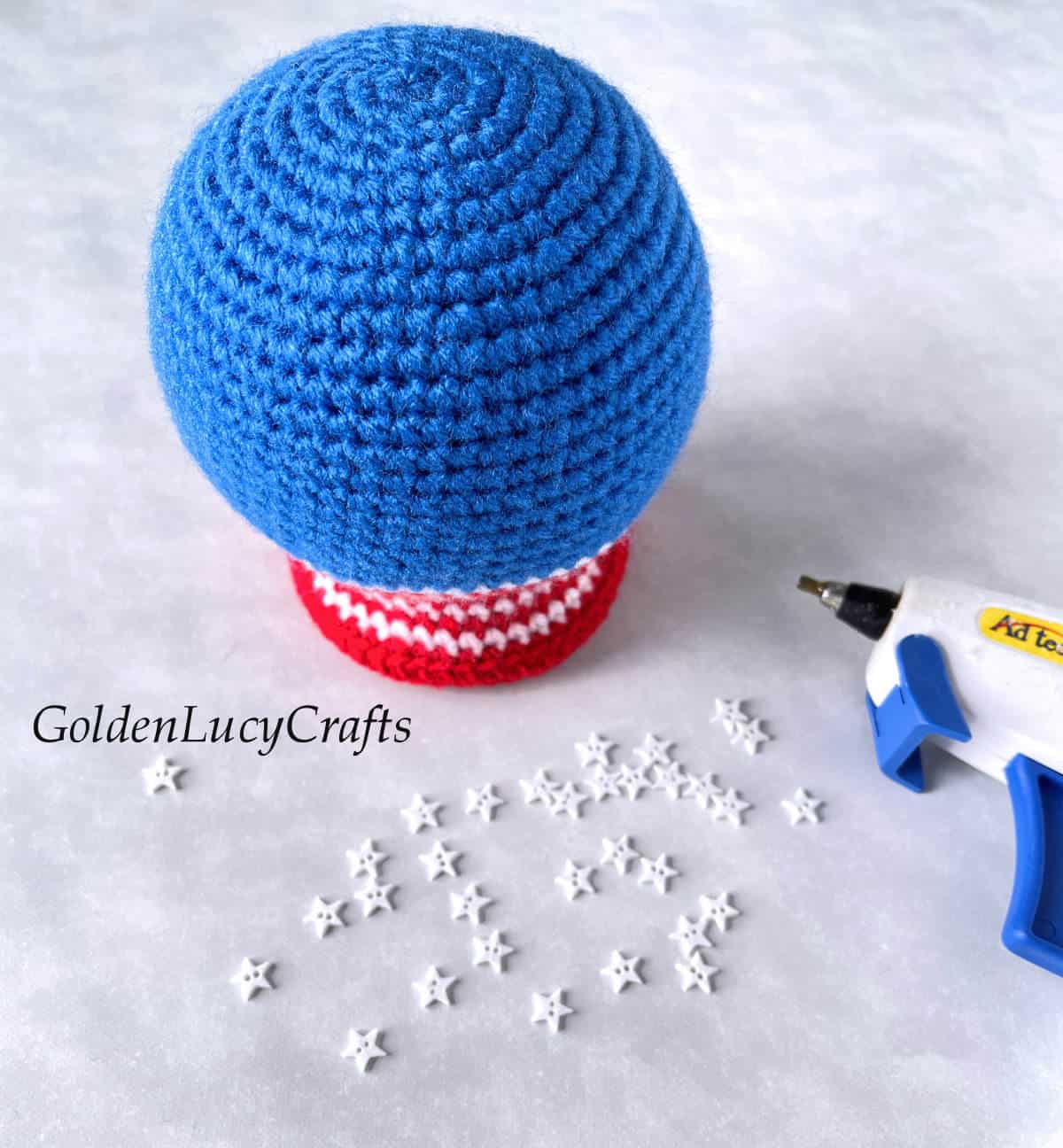 Crocheted snow globe, hot glue gun, small star buttons.