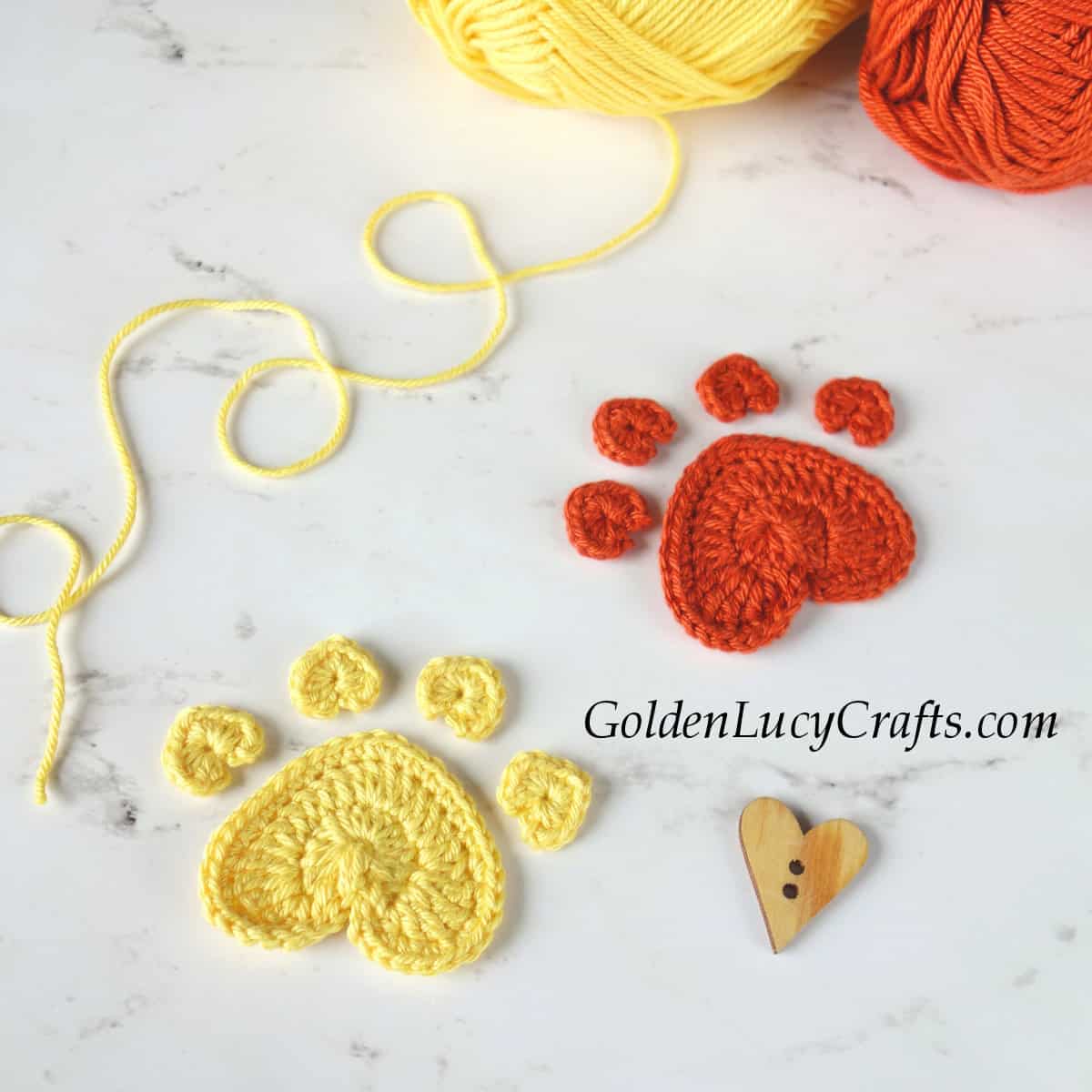 Crochet heart-shaped paw print appliques.
