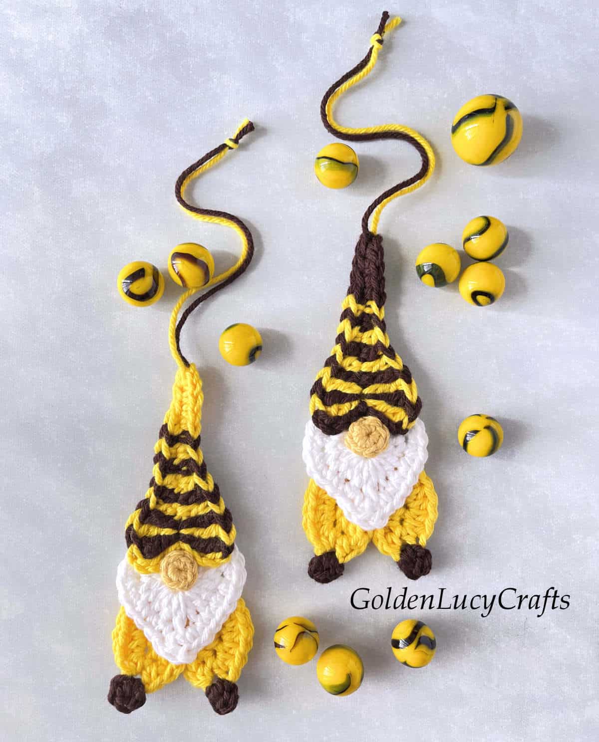 Two crocheted bee gnomes and bee marbles.
