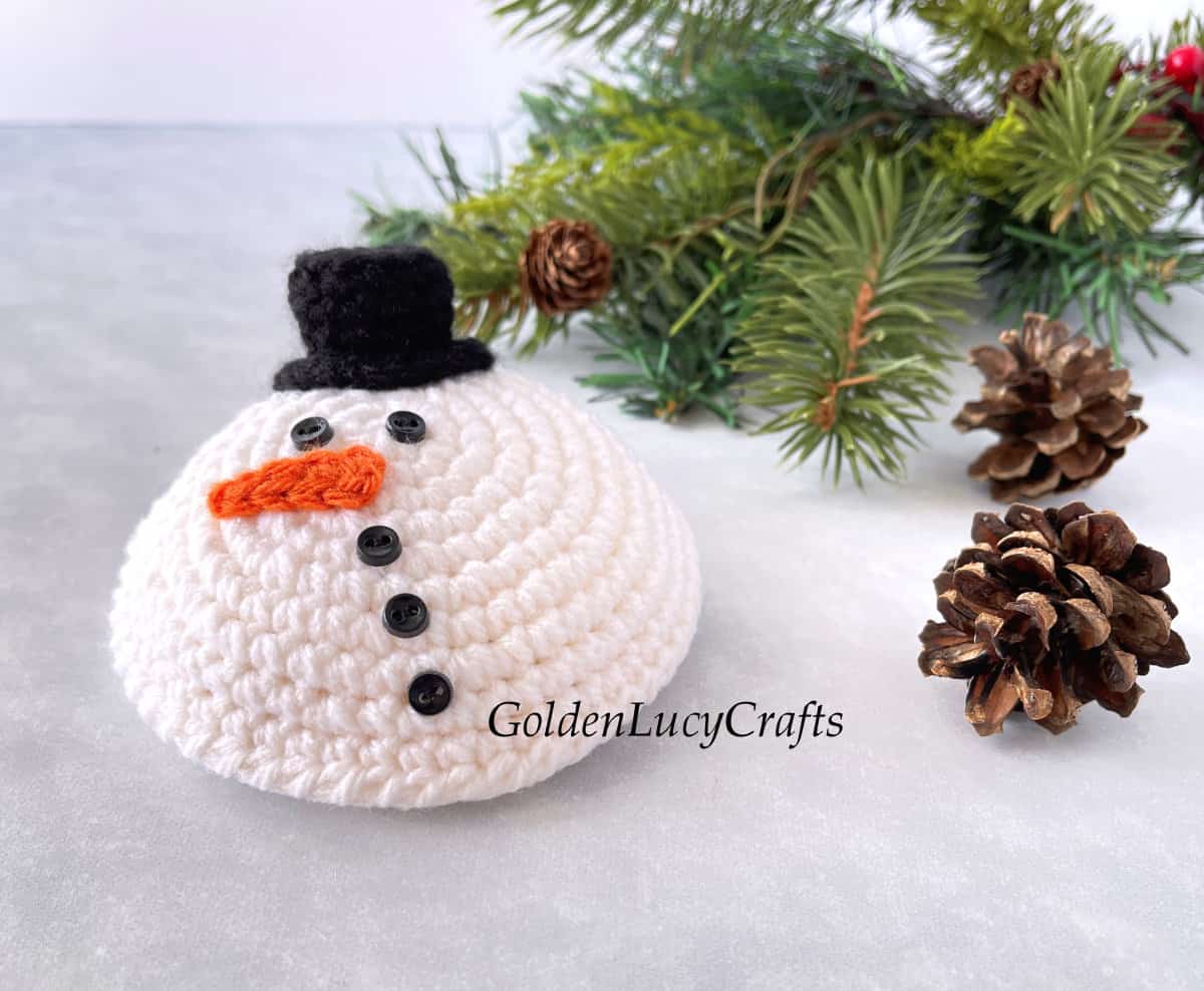 Crochet melted snowman amigurumi, two pine cones, Christmas tree branch.