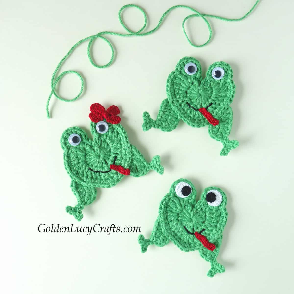 Three green crocheted heart-shaped frogs appliques.