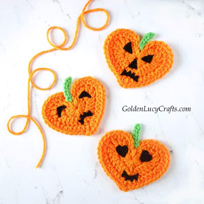 Three crocheted pumpking hearts.