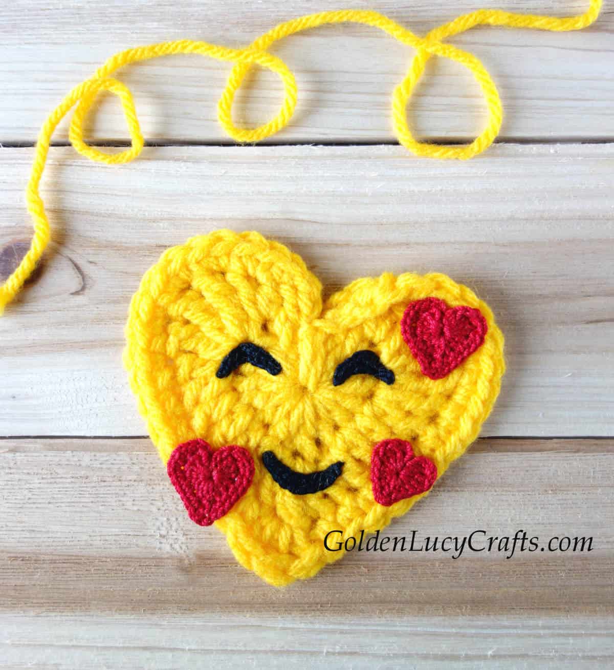 Crochet heart emoji smiling face with hearts.
