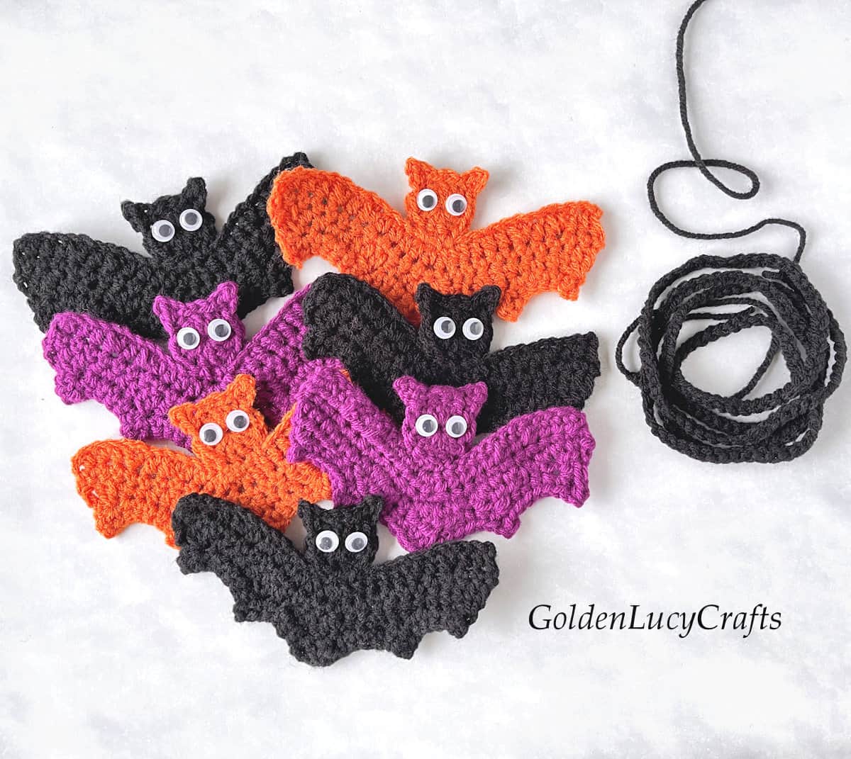 Crocheted bat appliques in black, purple and orange colors.