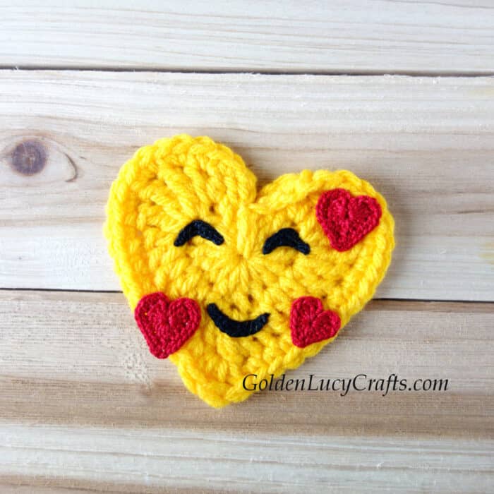 Crochet heart-shaped smiling face emoji.