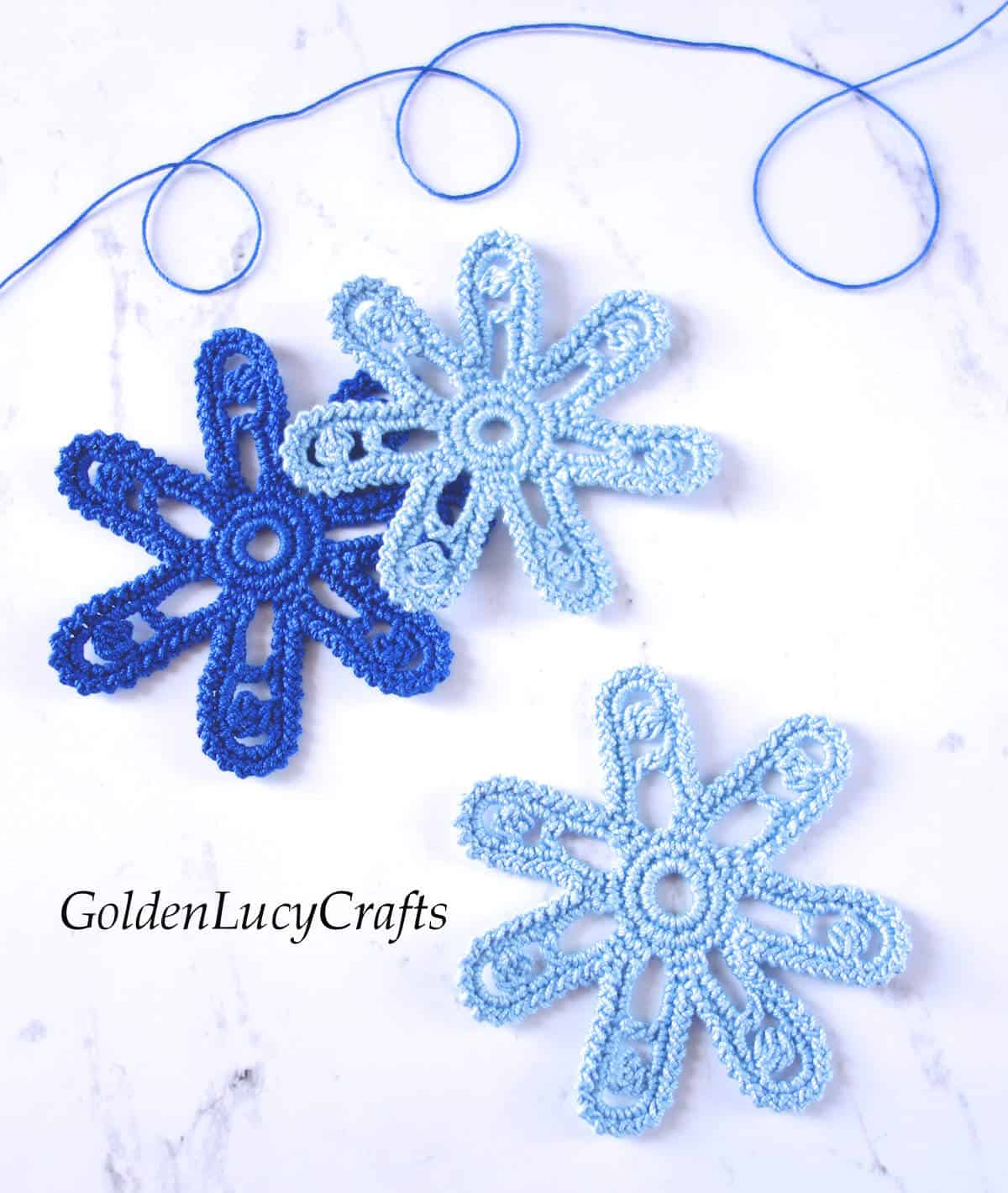 Three crocheted Irish flower motifs in blue colors.