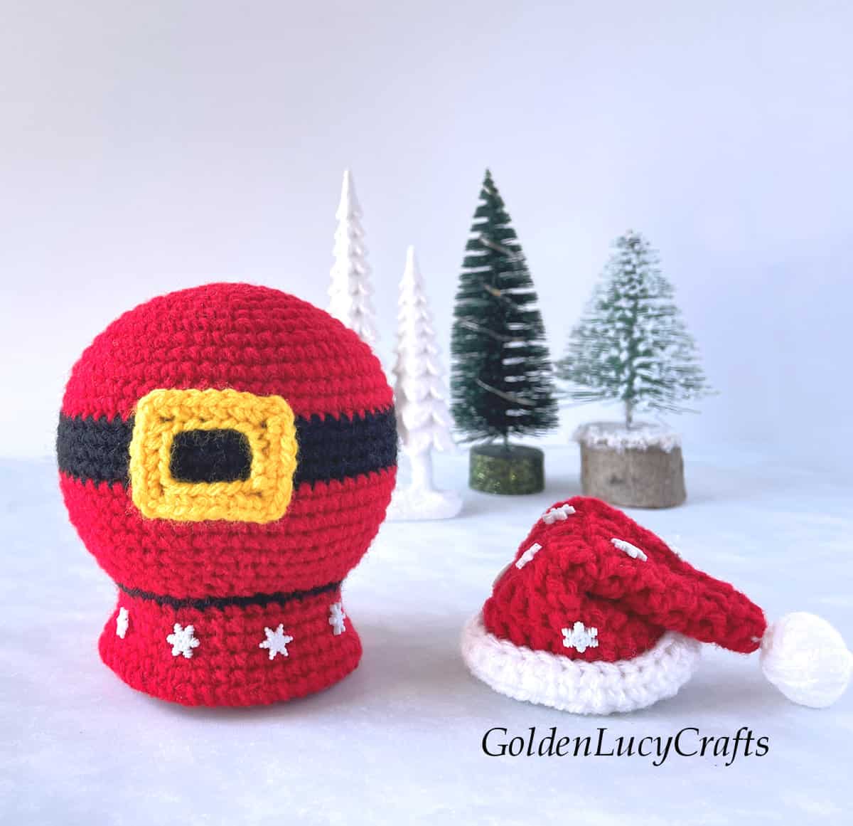 Crochet Santa belly snow globe, mini Santa hat next to it.
