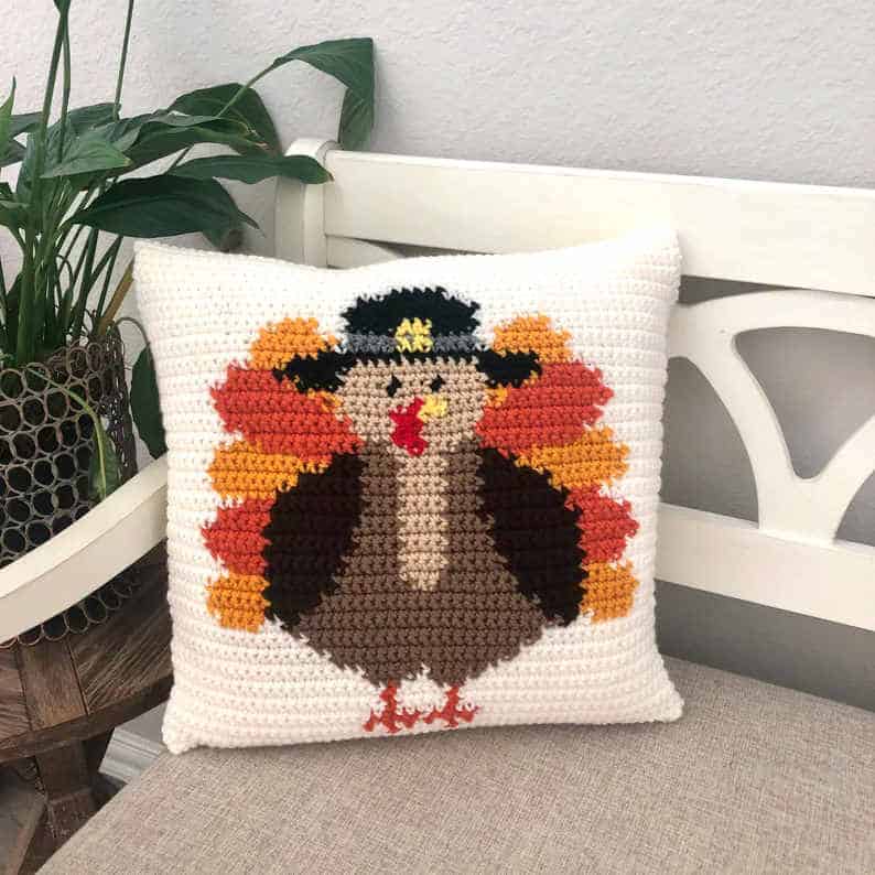 Crochet pillow with Thanksgiving turkey on it.