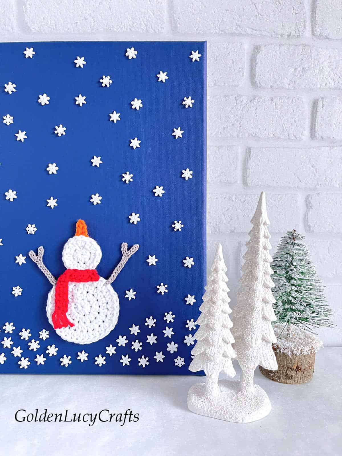 Crochet wall art snowman catching snowflakes close up picture.