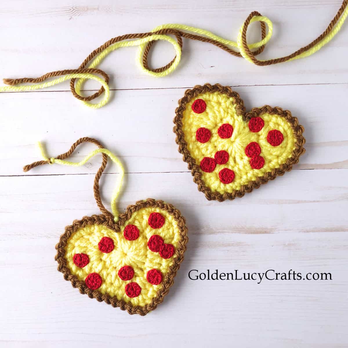 Two crocheted heart-shaped pizza appliques.