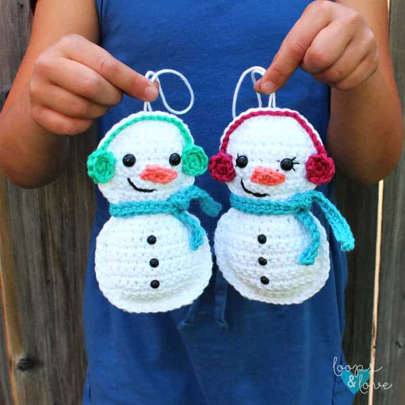 Model holding two crocheted snowmen.