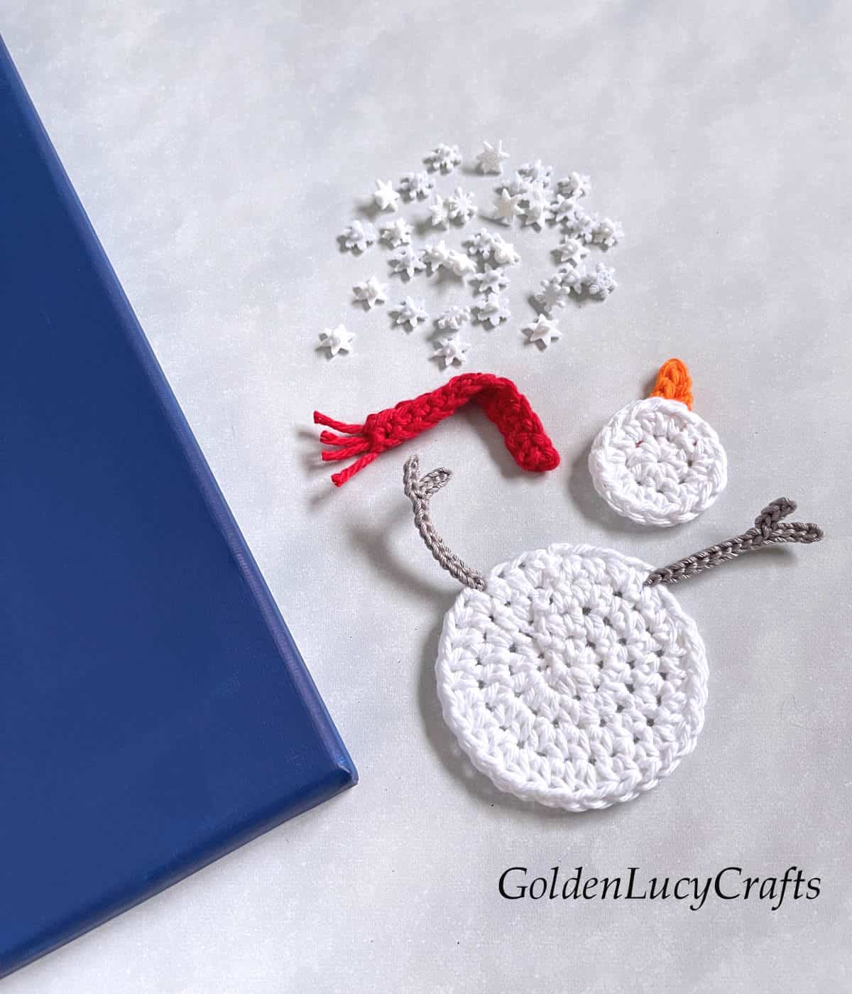 Making crochet wall art snowman catching snowflakes - process shot.