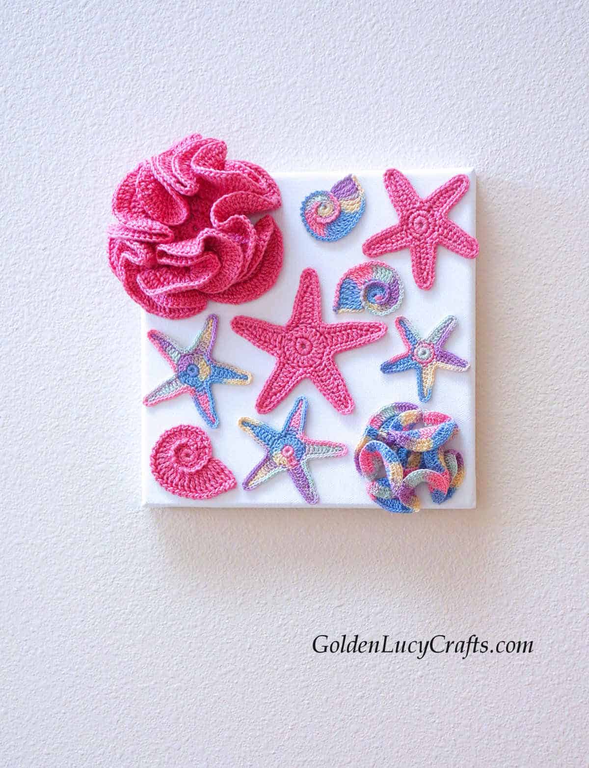 Crochet wall art pink and multicolored sea stars, corals.