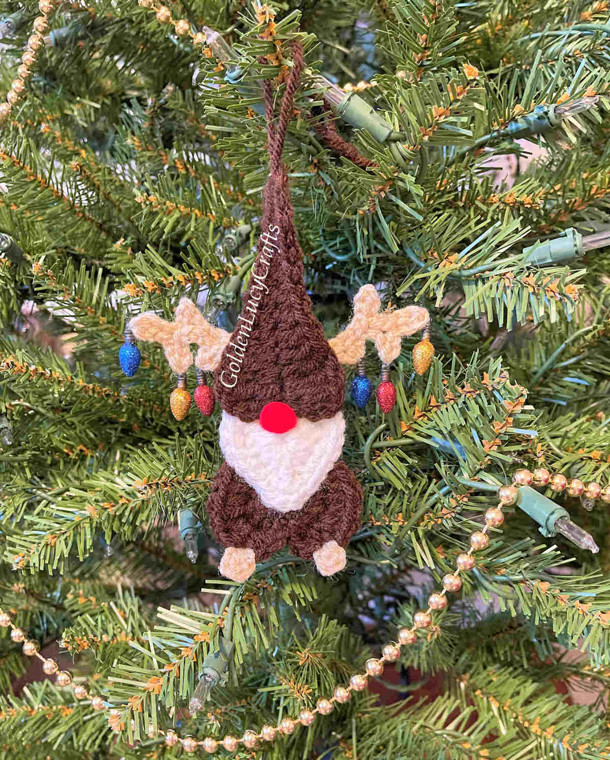 Crochet reindeer gnome ornament on a Christmas tree.