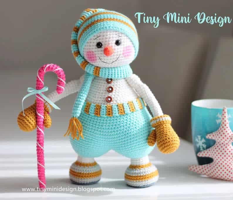 Crocheted snowman toy with a candycane.