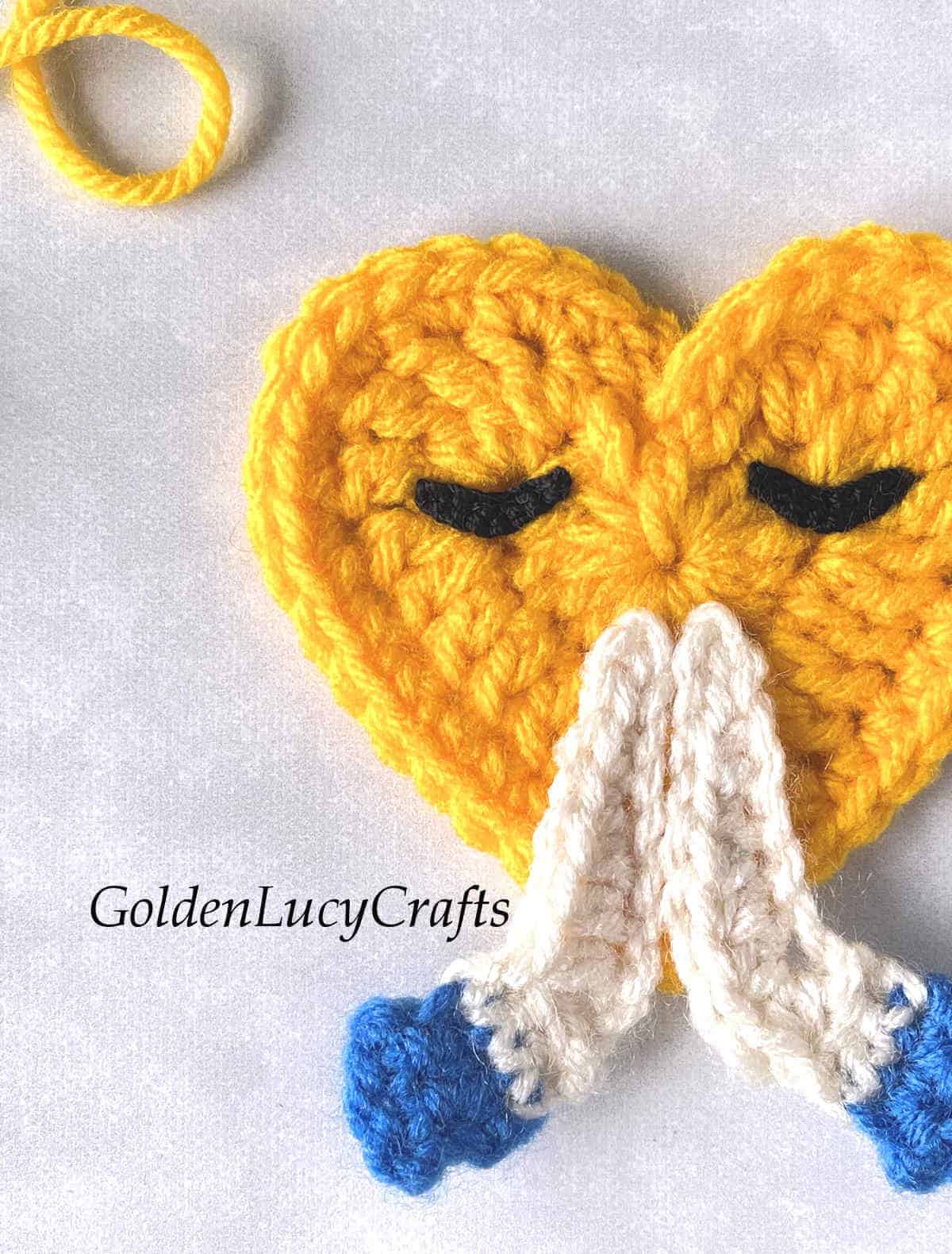 Crochet praying hands emoji close up picture.